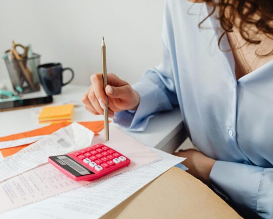 woman using calculator with paperwork