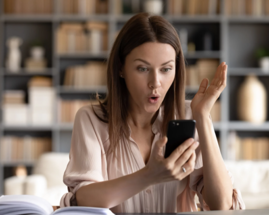 women excited by what shes looking at one her phone